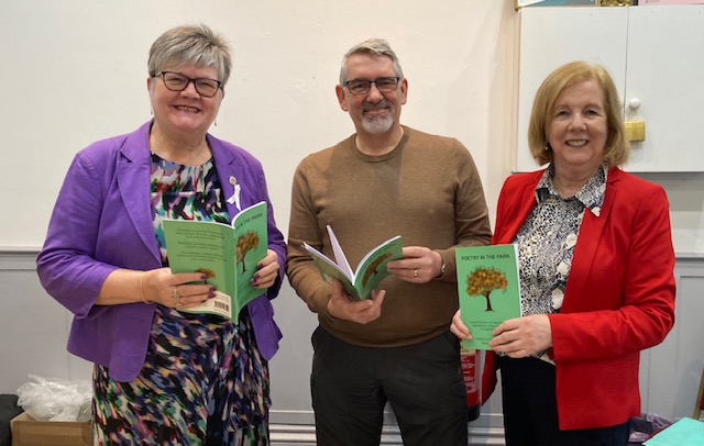 Photo of Janet Emsley, Seamus Kelly and Elizabeth White with copies of “Poetry in the Park”